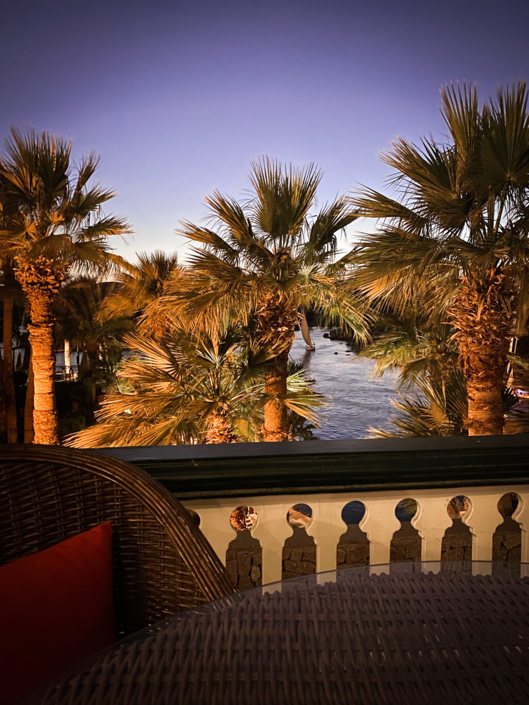A whicker table and chair sitting on the Victorian-era terrace overlooking the Nile at the Sofitel Old Cataract Hotel in Aswan, Egypt