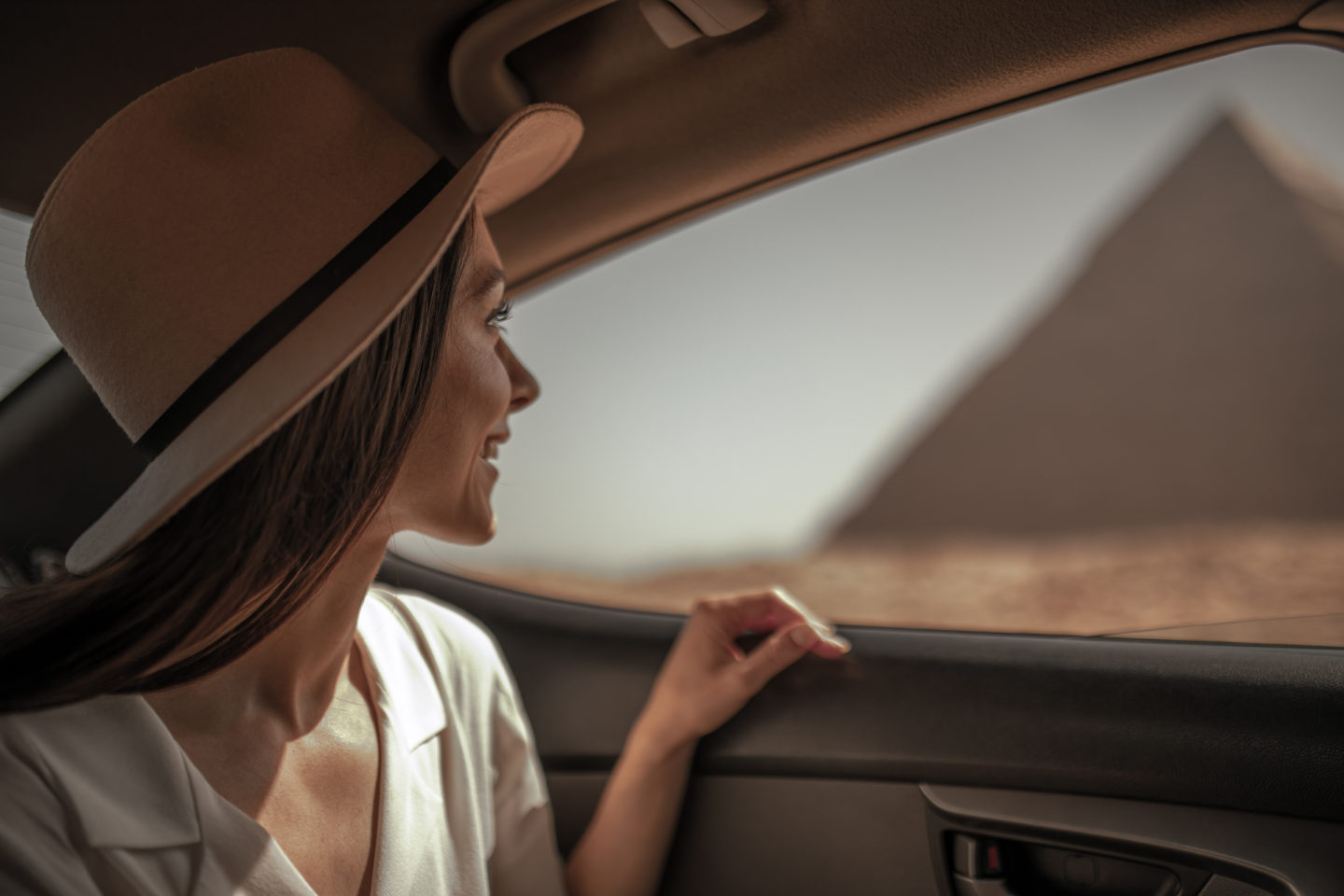 Solo Female Traveler Staring out a car window at the Pyramids of Giza - safe in Egypt