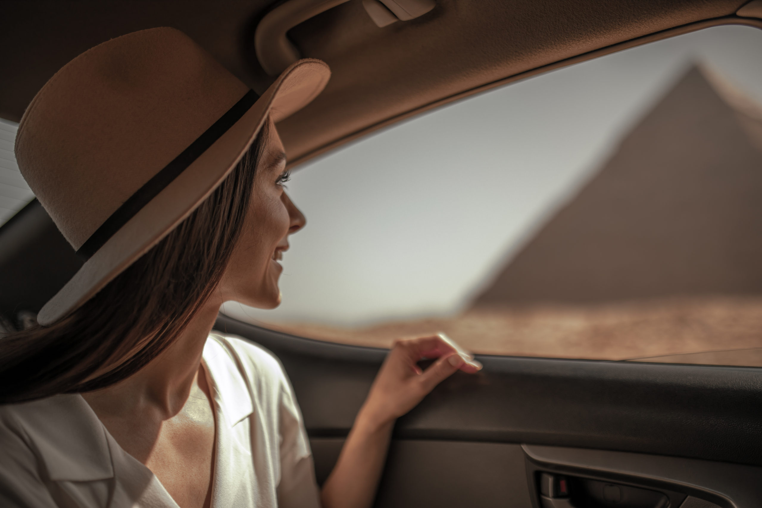 Solo Female Traveler Staring out a car window at the Pyramids of Giza - safe in Egypt