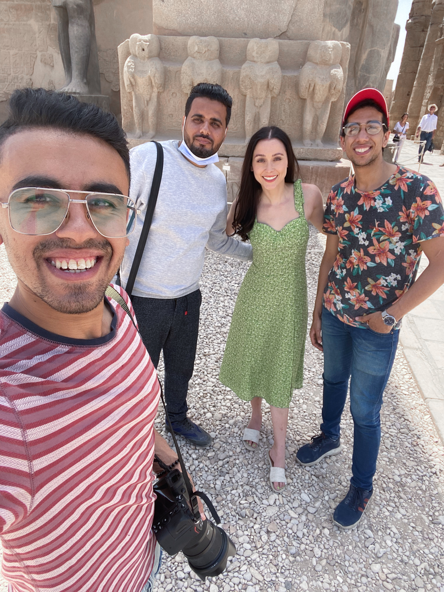Jordan Gassner wearing a green sundress and smiling with Egyptologist Ahmed Badawi and two local photographers and videographers, Mohamed Shraf and Mahmoud Esmat in Luxor, Egypt 