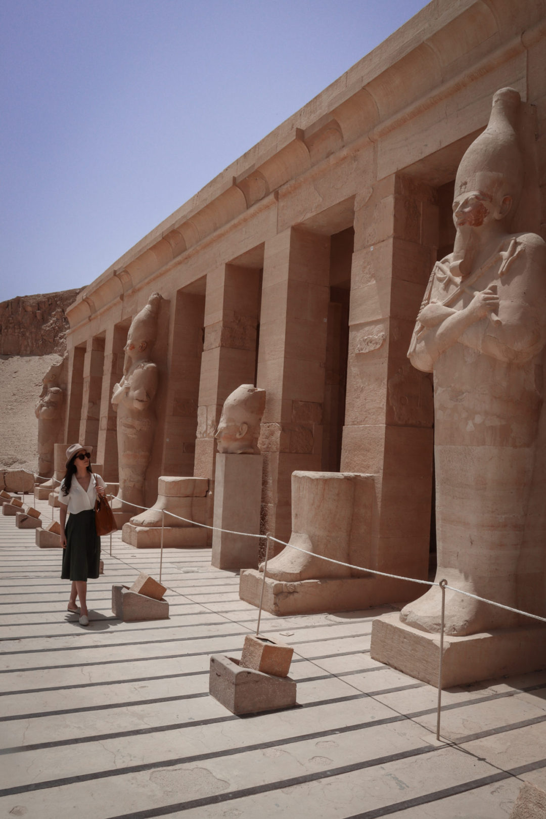 Jordan Gassner wearing an Indiana Jones inspired outfit while studying one of the Osiris statues that sit along the terrace of the Temple of Hatshepsut in Luxor, Egypt