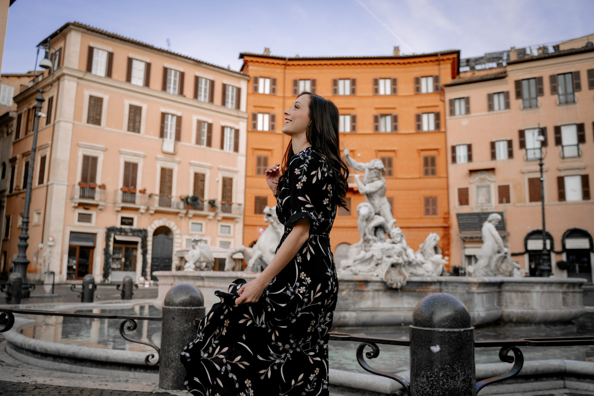 Jordan Gassner twirling in a black dress in front of one of the fountains at Piazza Navona in Rome, Italy