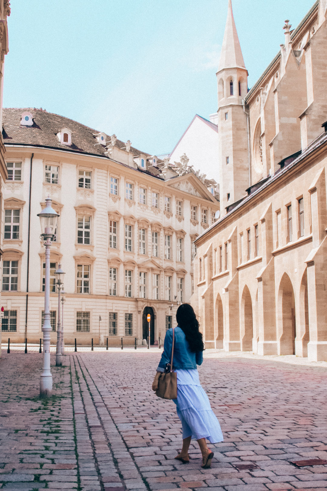 Travel Blogger Jordan Gassner walking along an empty cobblestone street in Vienna's Innere Stadt neighborhood