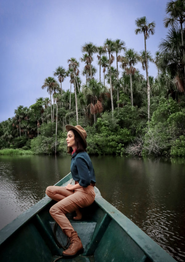Jordan Gassner wearing an explorer outfit while canoeing through Lake Sandoval, Tambopata National Reserve in Puerto Maldonado, Peru, The Amazon