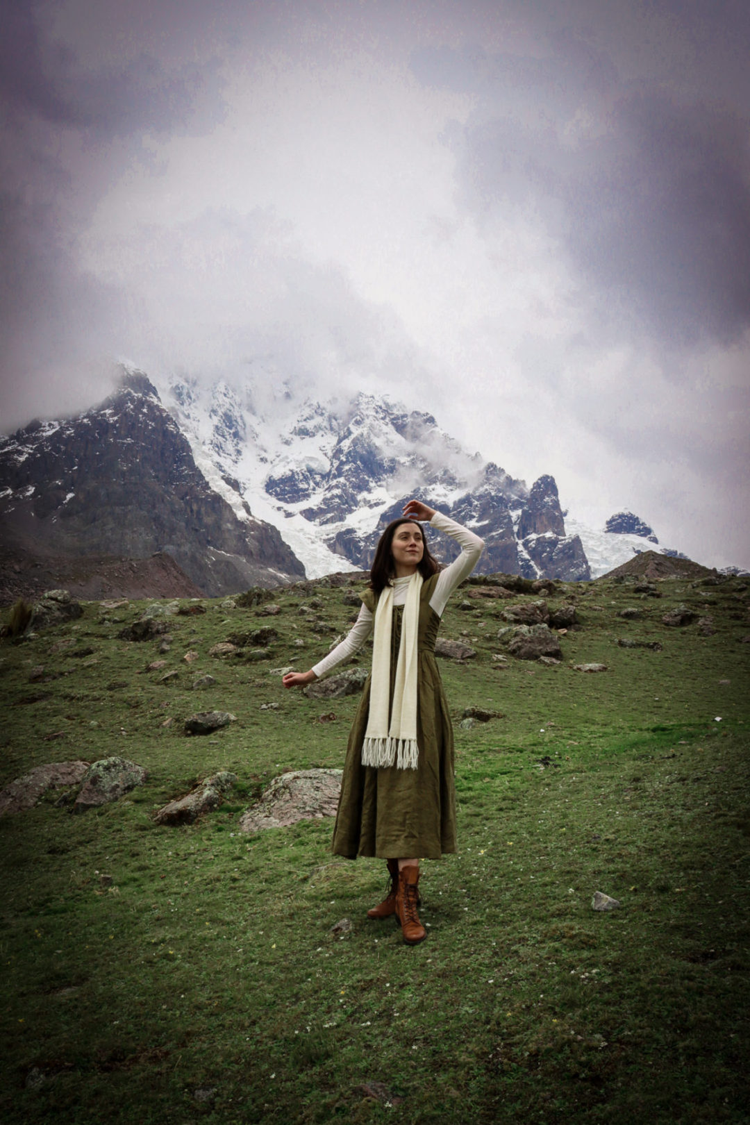 Jordan Gassner shielding her eyes while wearing a vintage Sound of Music inspired dress at the remote Ausangate Trek near Cusco, Peru