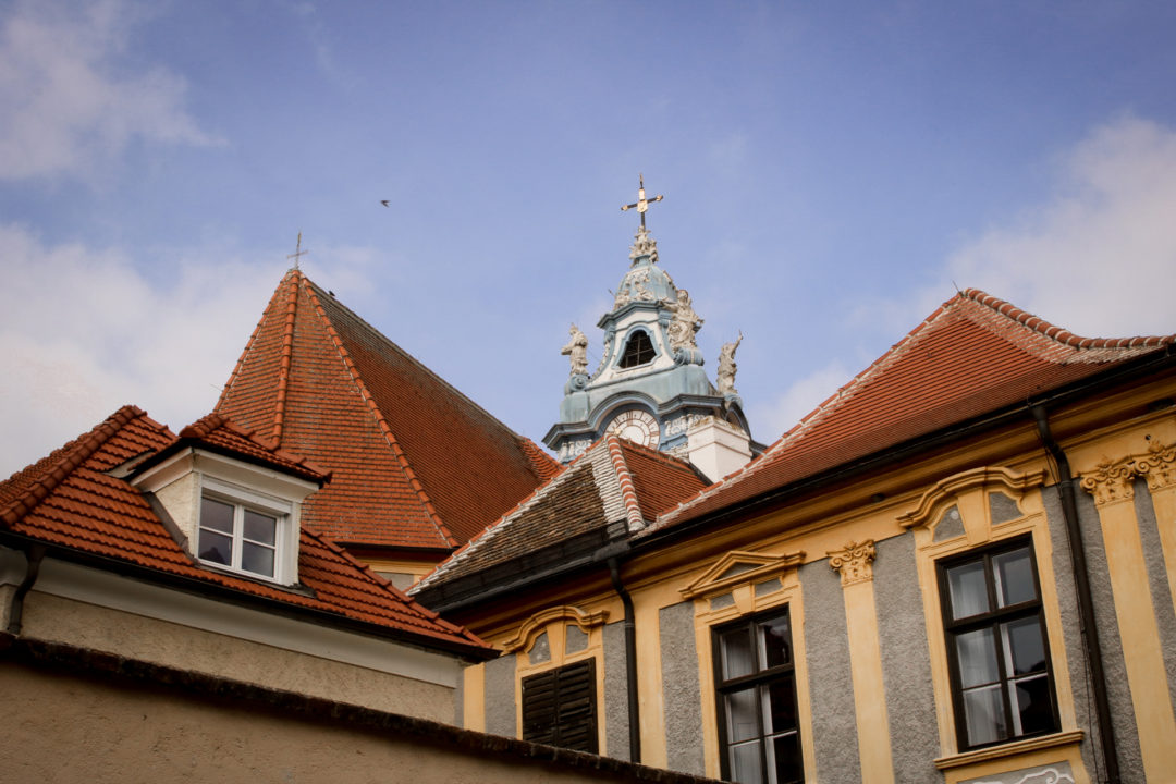 A view up at the red roofs and Blue Church Spire in the Old Town of Durnstein, Austria
