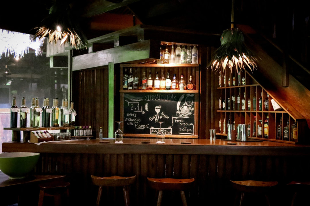 Wooden tiki bar with homemade flavored piscos and other alcohols at Inkaterra Reserva Amazonica in Puerto Maldonado, Peru