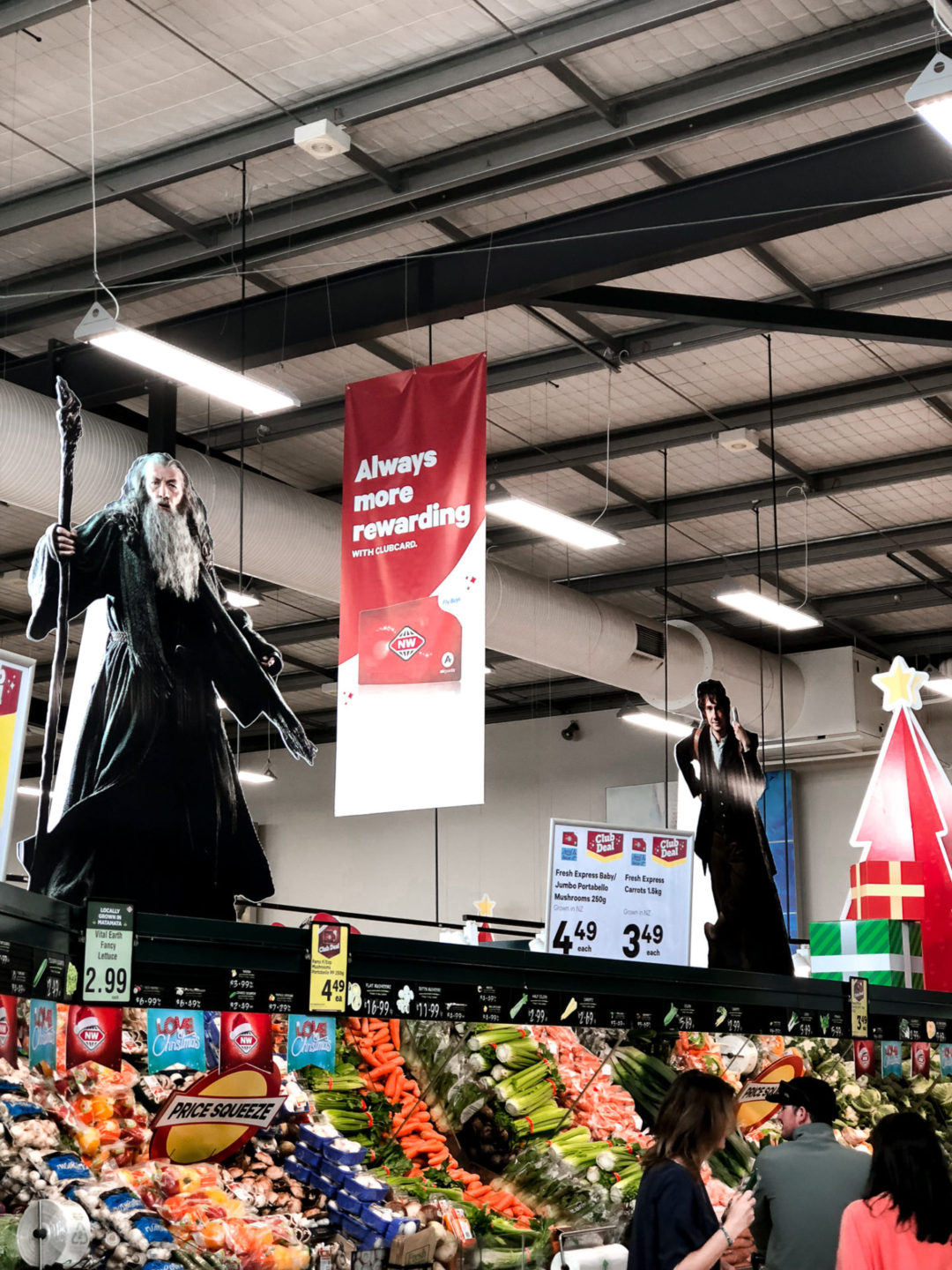 Lifesize Cardboard Cutouts of Gandalf and Bilbo Baggins sitting on top of the vegetable aisle at a local supermarket in Matamata, New Zealand