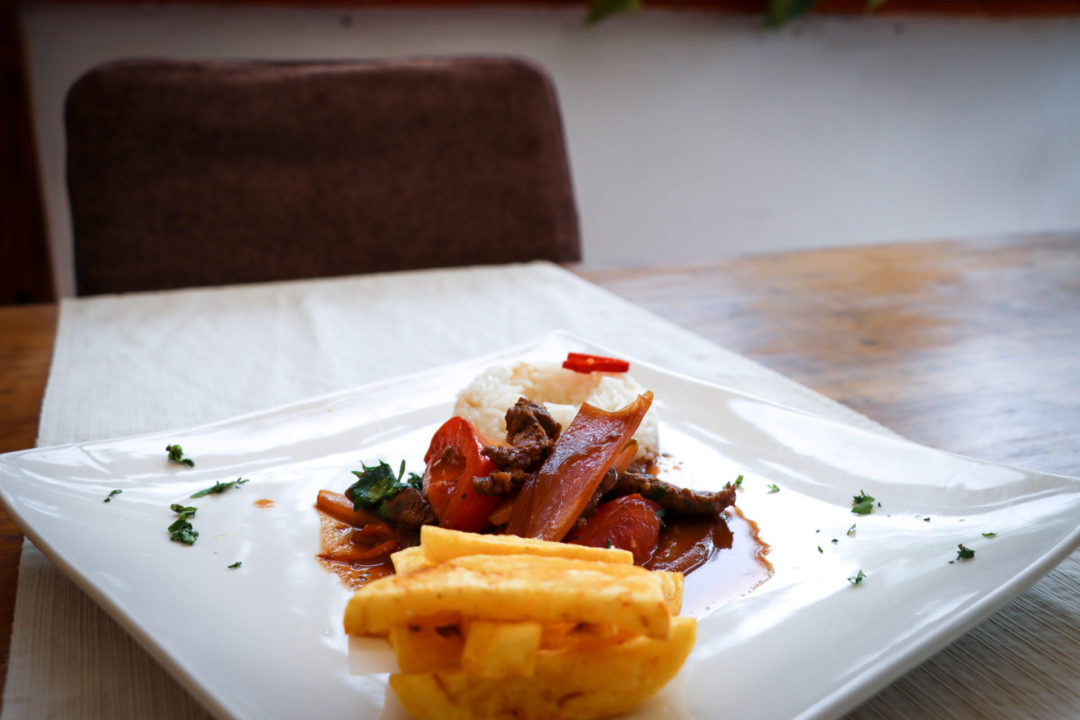 Freshly made Lomo Saltado, Rice and Fries on a white plate at SkyKitchen Cooking School in Lima, Peru