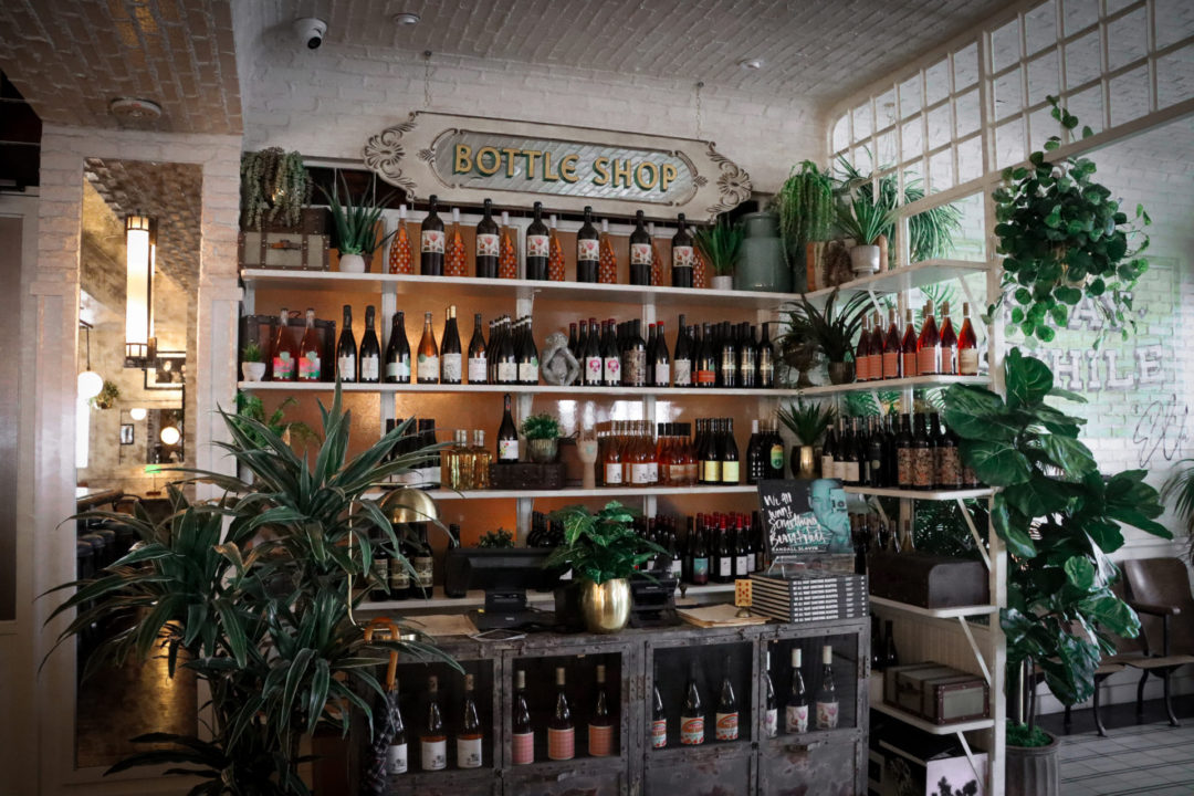Plants and bottles of natural red, rose and white wines line the shelves of Ella Beverly Hills' Bottle Shop