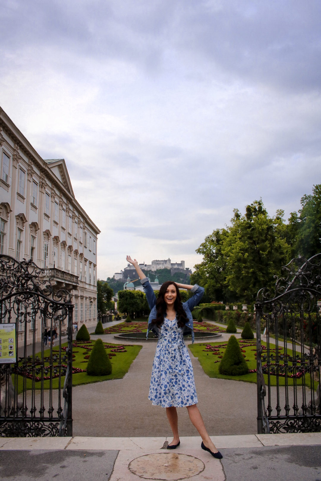 Travel Blogger Jordan Gassner doing a Sound of Music pose in front of the Mirabell Palace Garden in Salzburg, Austria