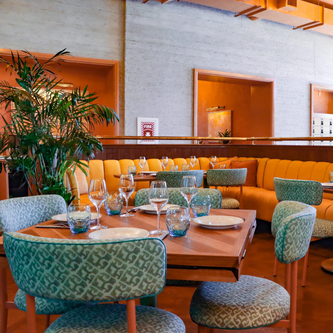 A few of the yellow and turquoise tables inside the Mother Tongue Restaurant Dining Room
