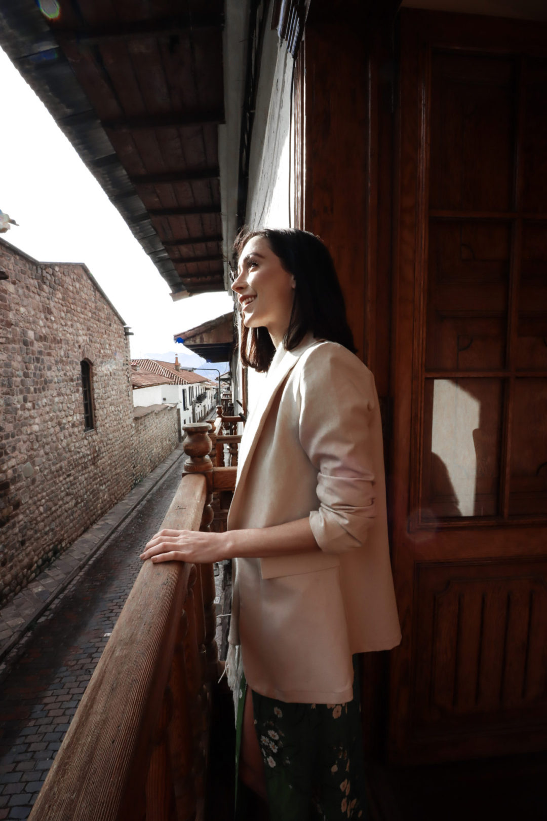 Travel Blogger Jordan Gassner taking a few tripod travel photos of herself from a hotel balcony in Cusco, Peru