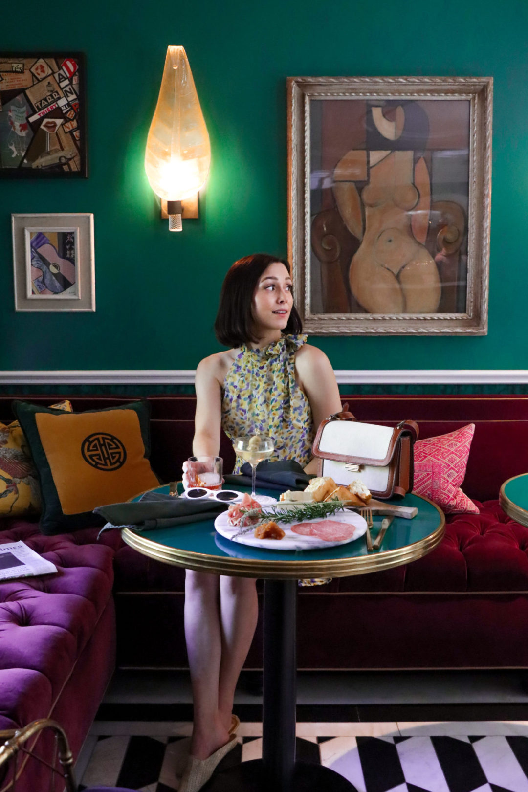 Travel Blogger Jordan Gassner sitting in the lobby of The colorful, art-deco inspired Hollywood hotel, The Prospect, with a martini and a charcuterie platter