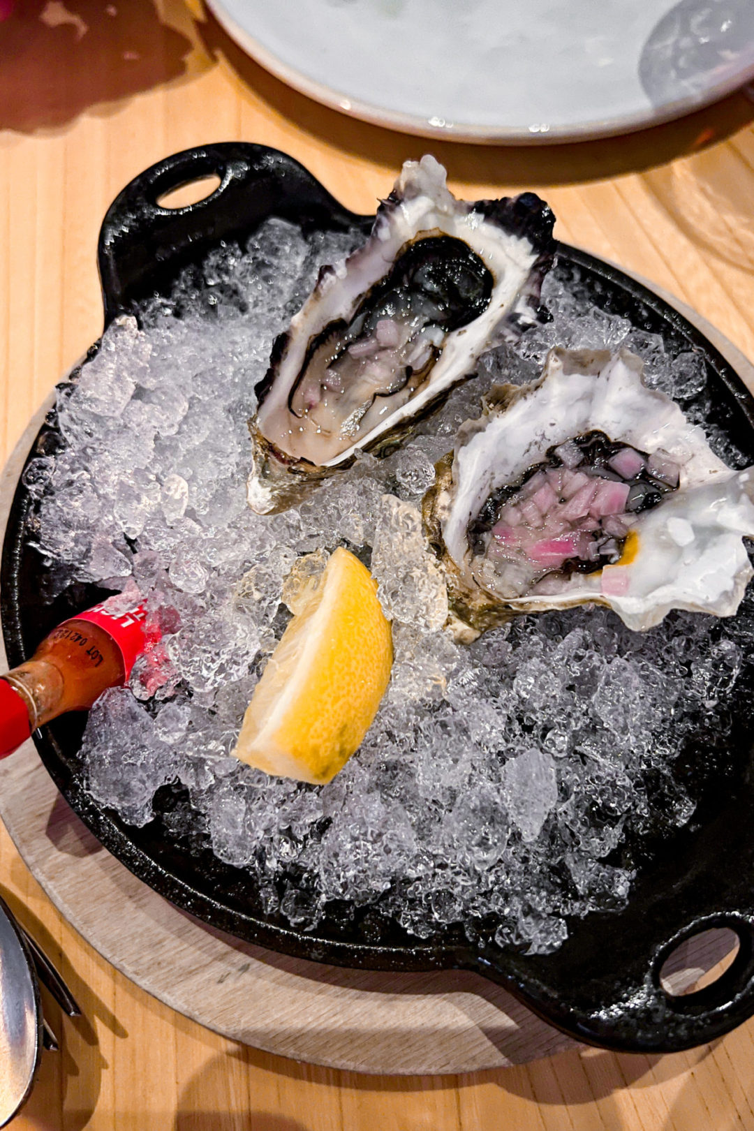 Two oysters on ice with a lemon slice and hot sauce at Michael Mina's Wit + Wisdom Restaurant in Sonoma, California
