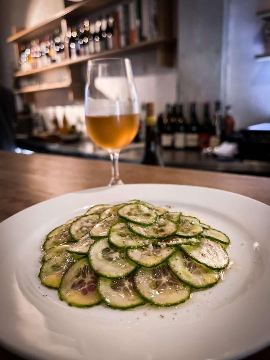 A glass of orange wine and the charred cucumber starter at Hugo Wine Bar in Mexico City