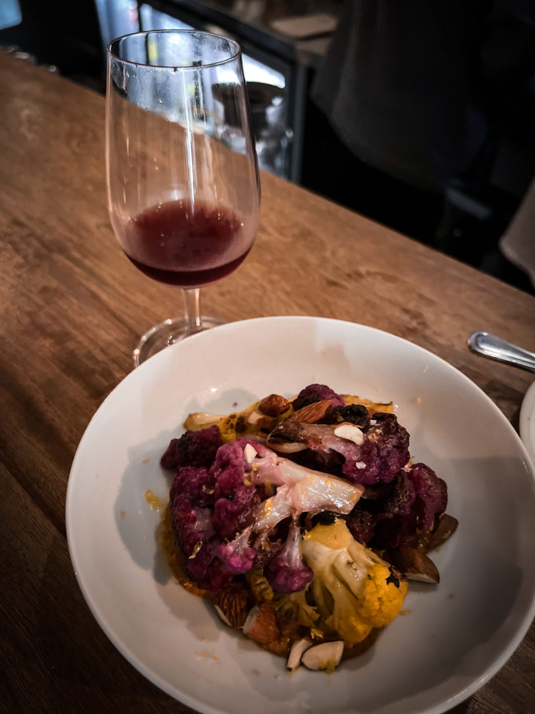 A glass of Kikiriki red wine with a cauliflower dish at Hugo Wine Bar in Mexico City