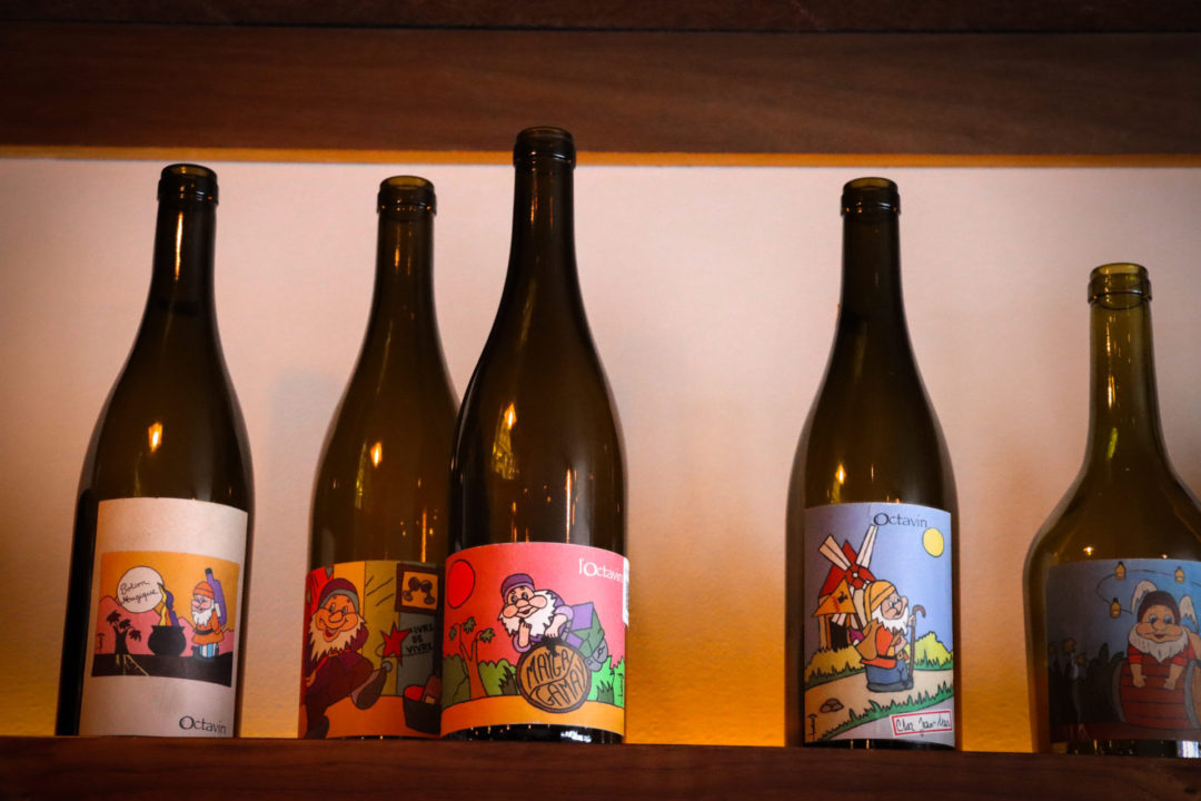 5 bottles of natural wine sitting on. a shelf at Loup Wine Bar in Mexico City's Roma Norte neighborhood