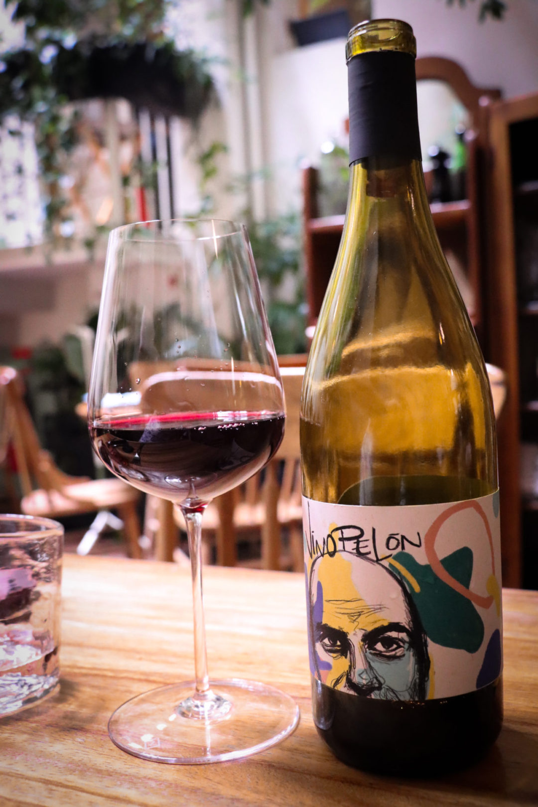 A glass of red wine next to a bottle of Vino Pelón at Restaurante Rosetta in Mexico City's Roma Norte neighborhood