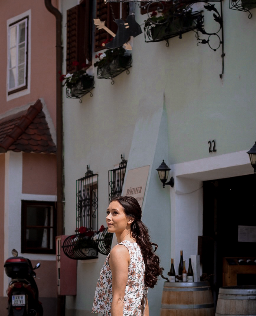 Travel Blogger Jordan Gassner walking by a wine shop in the Old Town of Durnstein, Austria