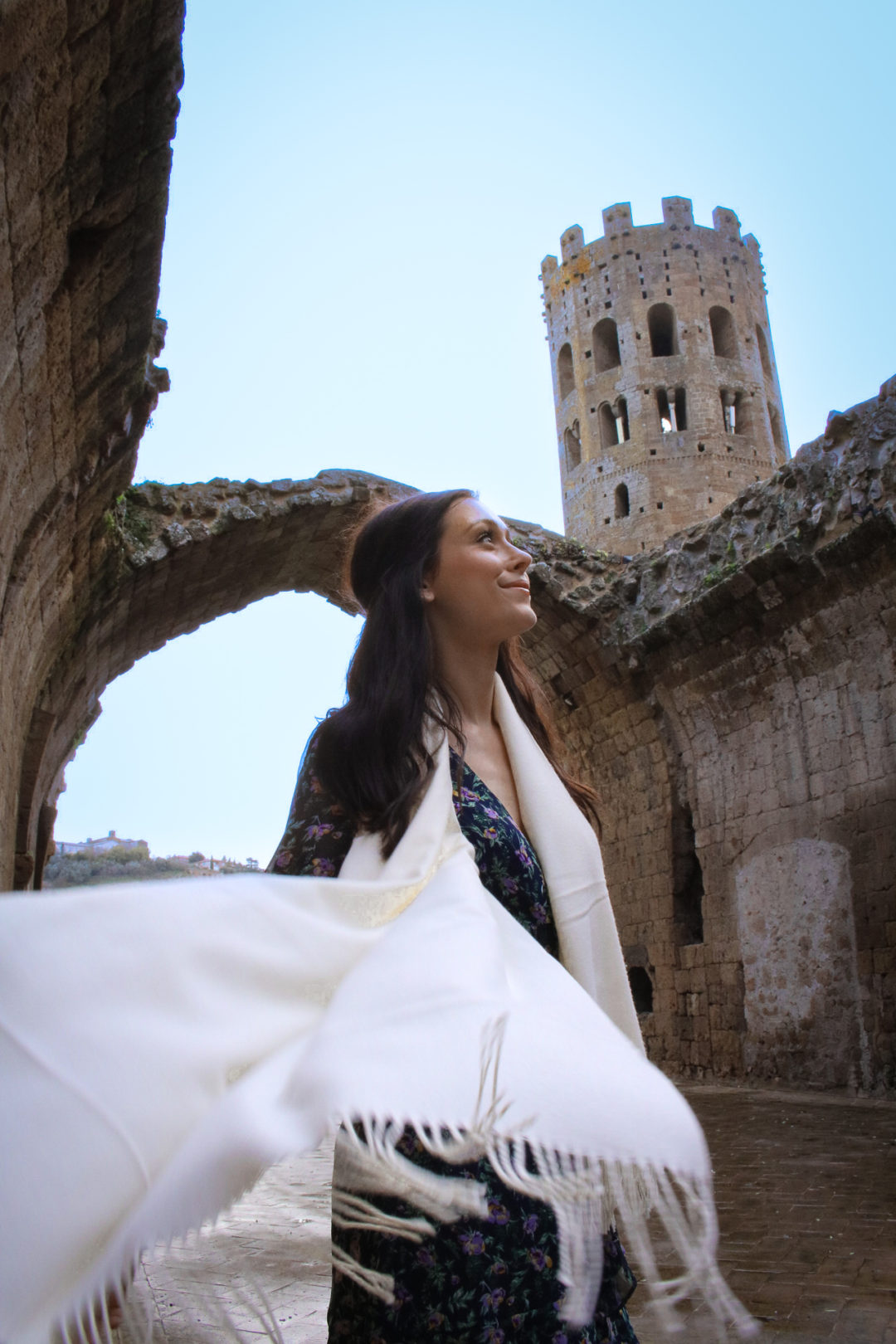 Travel Blogger Jordan Gassner wearing a cream scarf blowing toward the camera in Orvieto, Italy