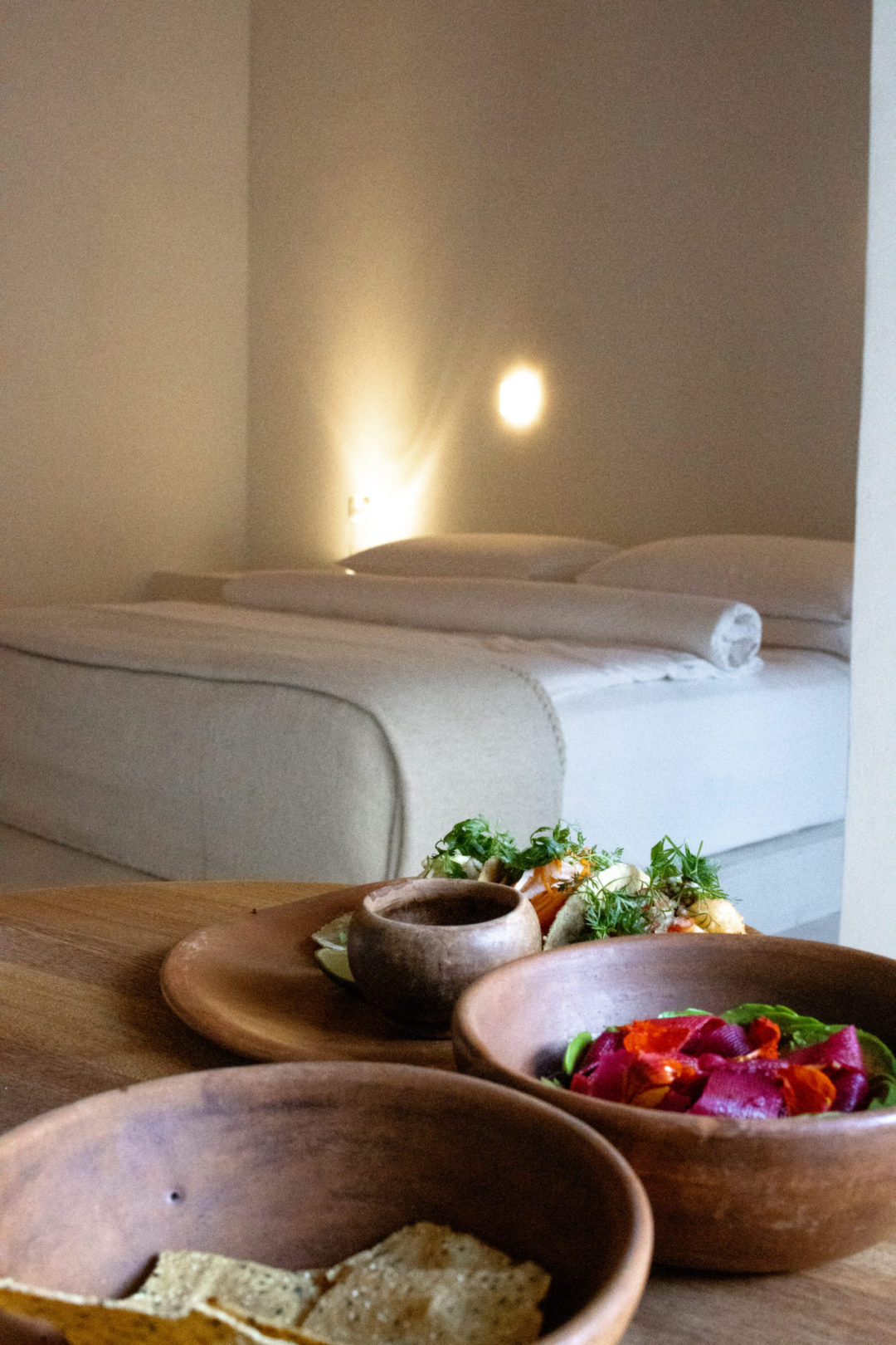 Tacos Baja and Aguachile Vegano on a table near a made-up bed at the Círculo Mexicano Boutique hotel in Mexico City