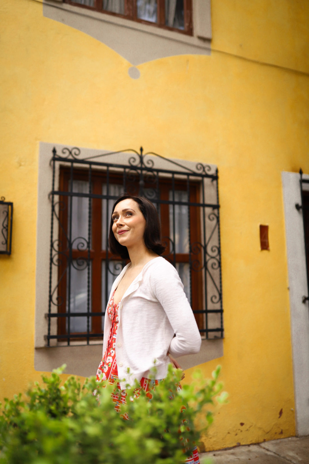 Travel Blogger Jordan Gassner smiling in front of a yellow painted home in Coyoacán Mexico City