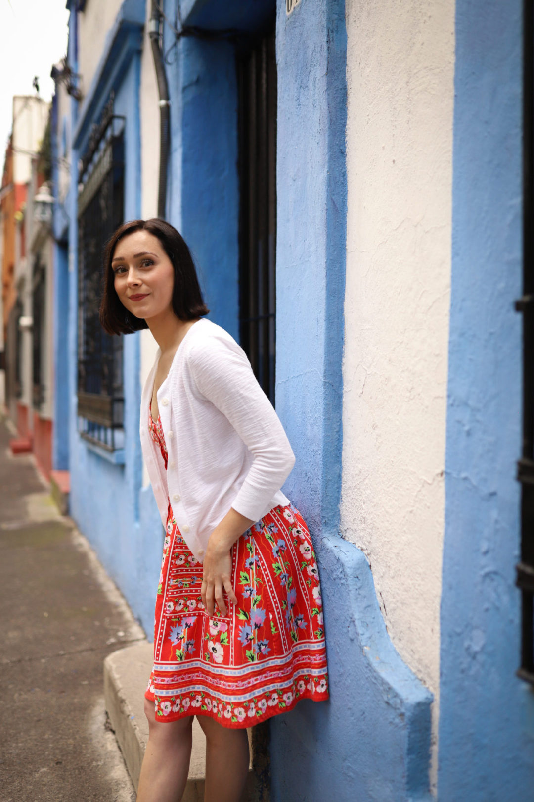 Travel Blogger Jordan Gassner leaning against a sky blue and white painted home in Coyoacán Mexico City