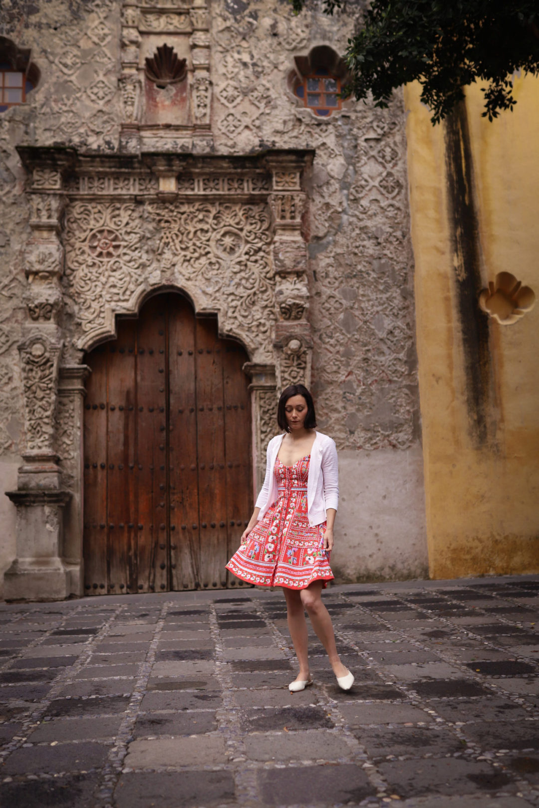 Travel Blogger Jordan Gassner twirling in a red dress in front of Capilla de La Conchita in Coyoacán Mexico City