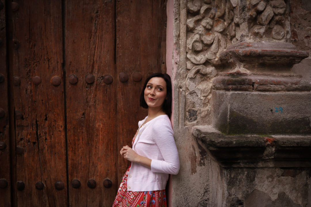 Travel Blogger Jordan Gassner leaning against the intricate stone archway at the front of Capilla de La Conchita