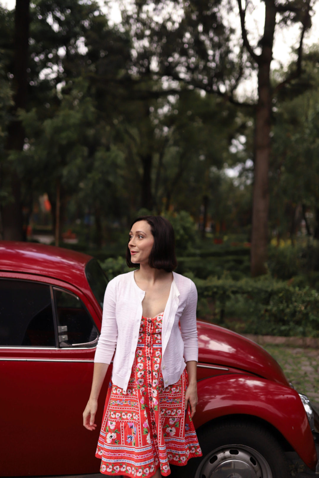 Travel Blogger Jordan Gassner near a vintage red VW bug parked alongside Plaza De La Conchita in Coyoacán Mexico City