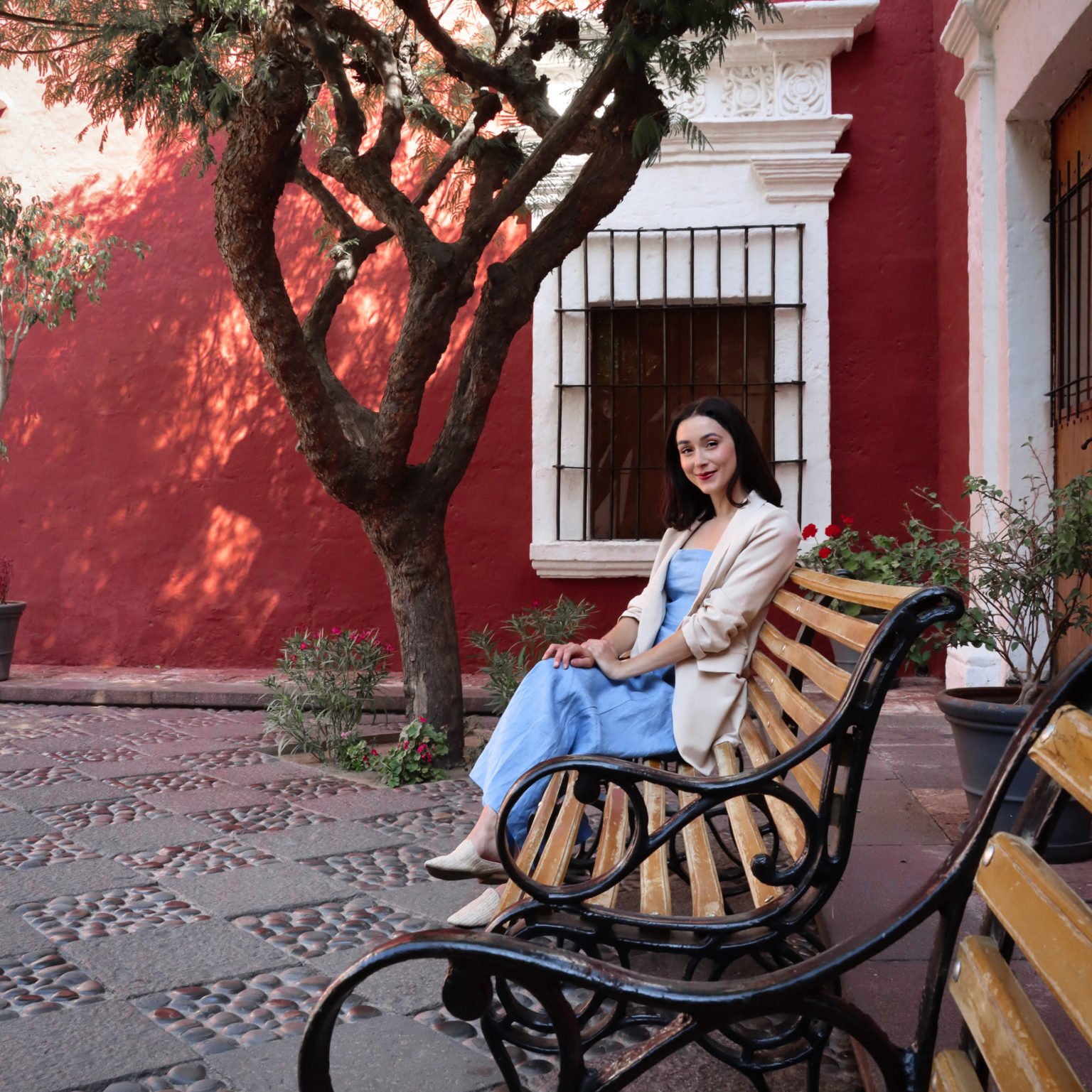 Travel Blogger Jordan Gassner sitting on a bench in front of on of the best sights in Arequipa: Museo Santuarios Andinos