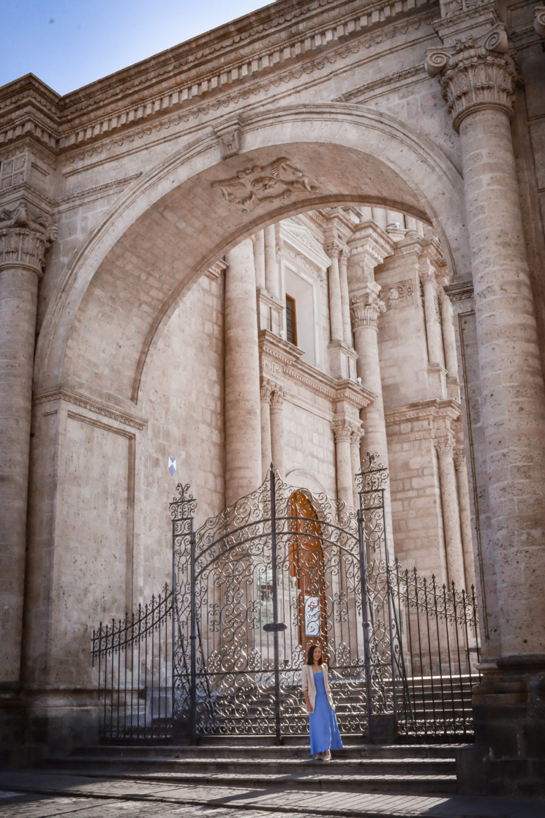 Travel Blogger Jordan Gassner standing outside a wrought iron gate leading up to the Basilica Cathedral of Arequipa