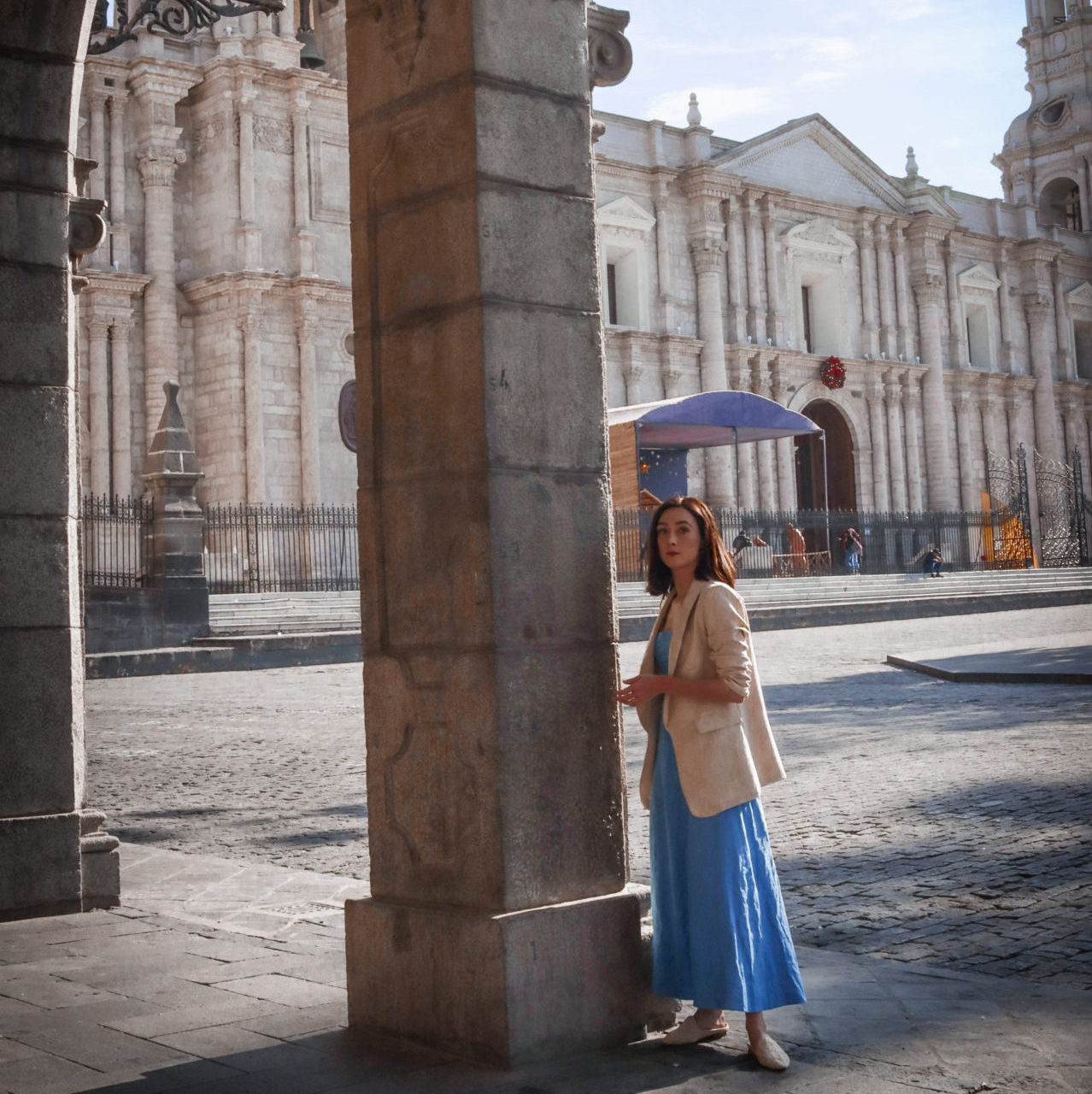 Travel Blogger Jordan Gassner standing under a colonnade in Arequipa's Plaza de Armas outside the Basilica Cathedral of Arequipa