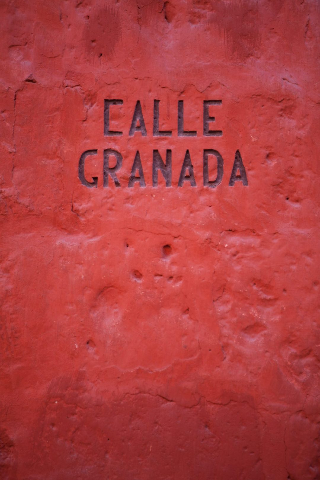 A red wall with the writing "Calle Granada" inside of the best sights in Arequipa: Santa Catalina Monastery