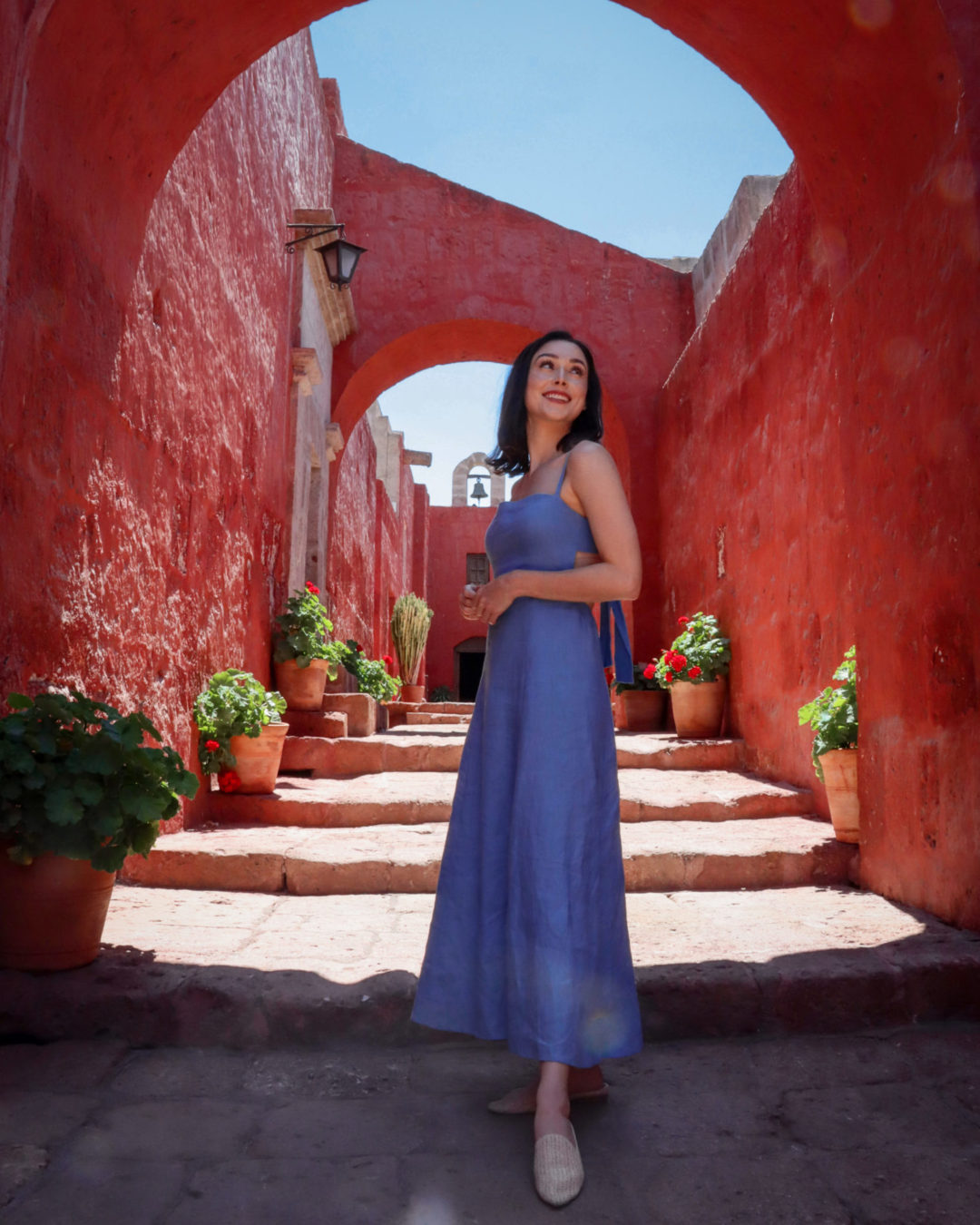 Travel Blogger Jordan Gassner standing under a red colonnade inside of the best sights in Arequipa: Santa Catalina Monastery