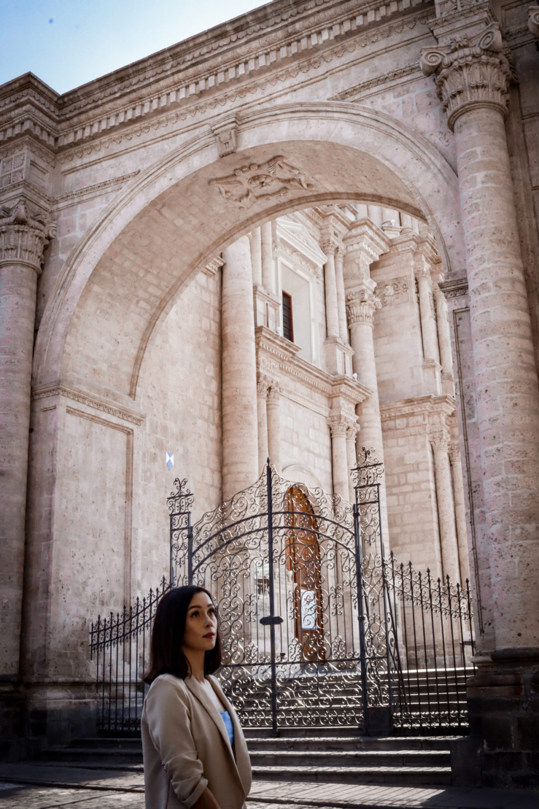 Travel Blogger Jordan Gassner standing near a wrought iron gate leading up to the Basilica Cathedral of Arequipa