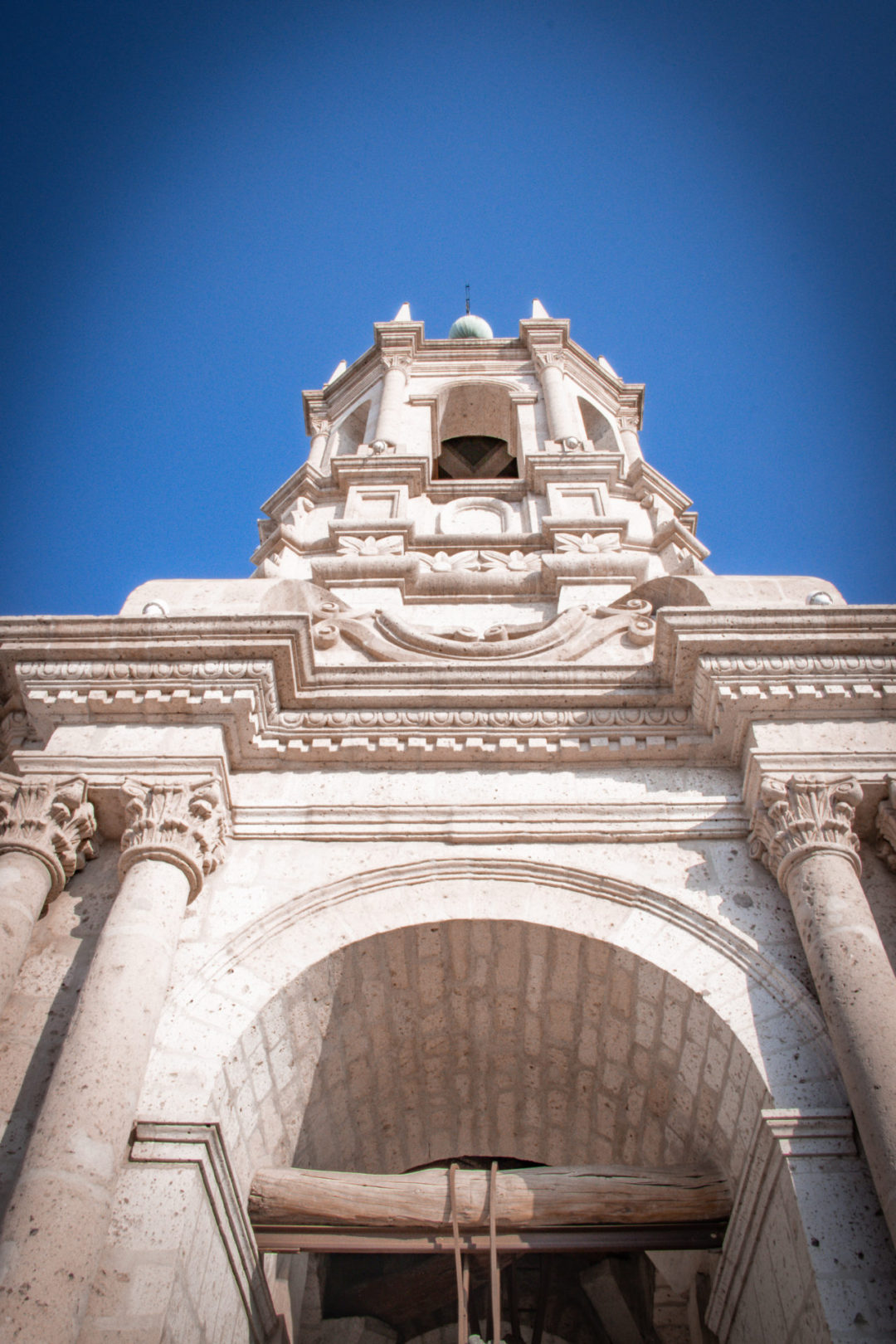 A low-angle shot of the white sillar belltower on top of Arequipa's Basilica Cathedral