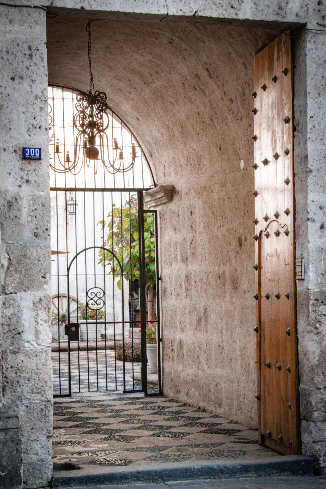 A tunneled exit with a wrought iron gate leading outside the Basilica Cathedral of Arequipa