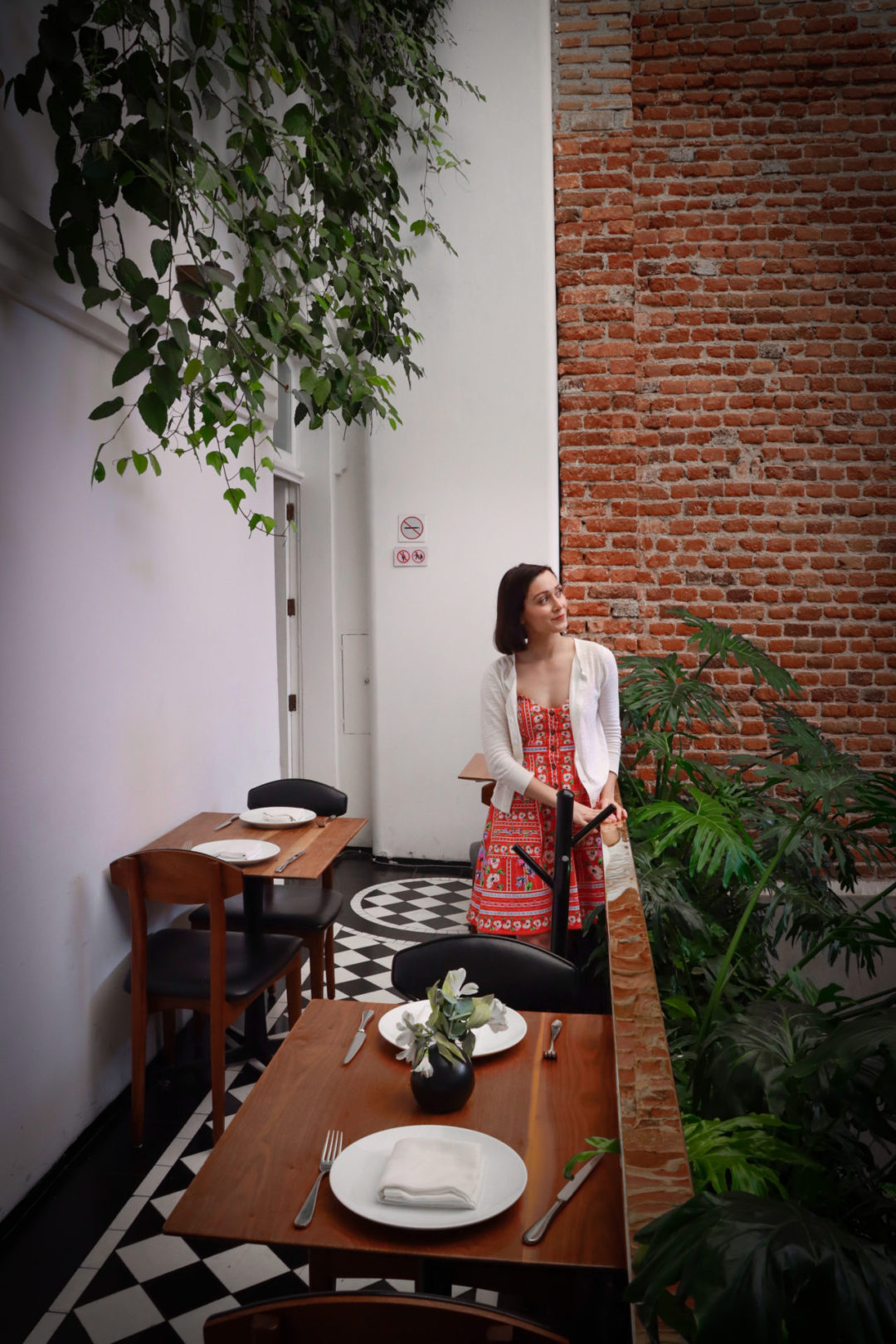 Travel Blogger Jordan Gassner leaning against the second floor railing and smiling inside Blanco Colima in Roma Nte. Mexico City