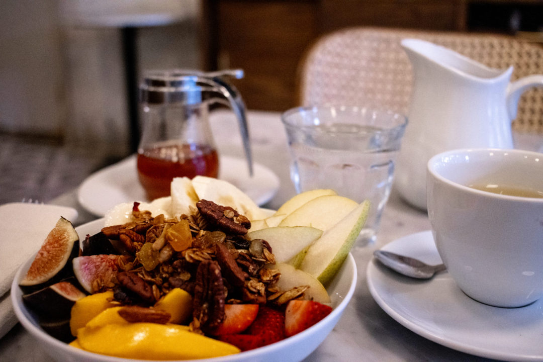 A bowl of fresh apples, strawberries, mangoes, bananas and figs topped with granola from Café Milou