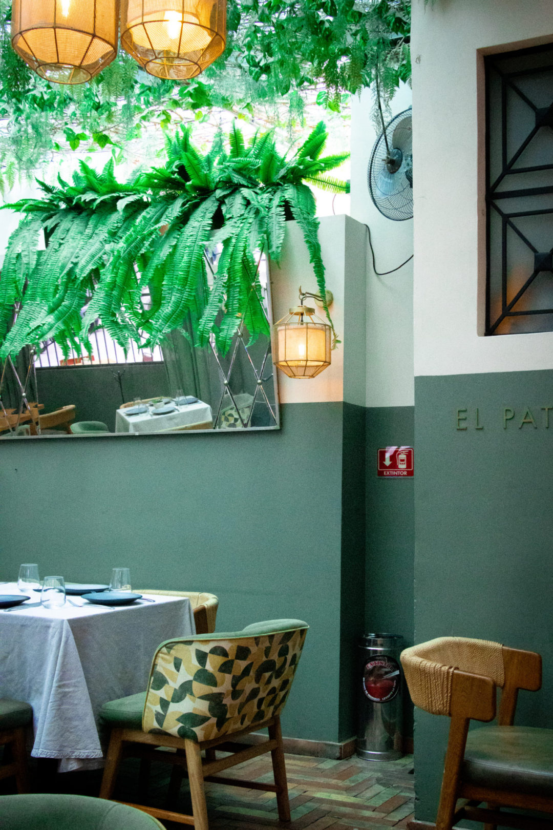 The green interior, funky chairs and faux-plant canopy inside Castizo: a great restaurant for eating dairy-free in Mexico City