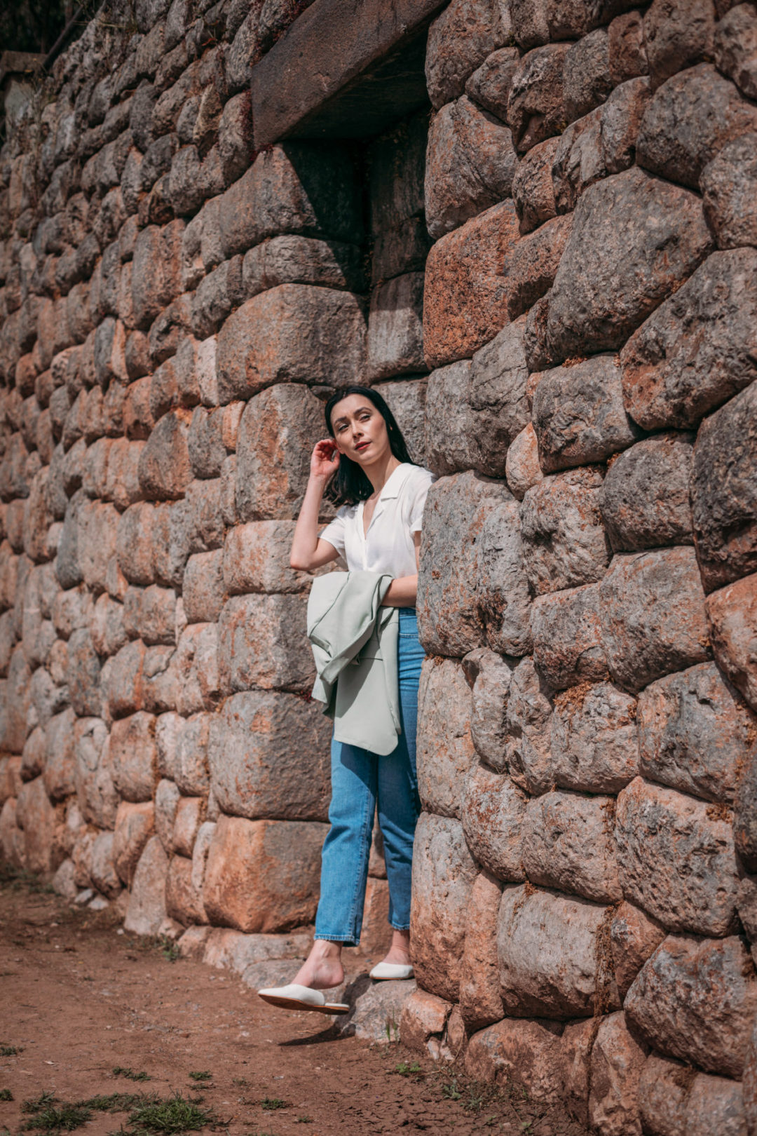 Travel Blogger Jordan Gassner stepping out of an ancient stone doorway in Cusco, Peru