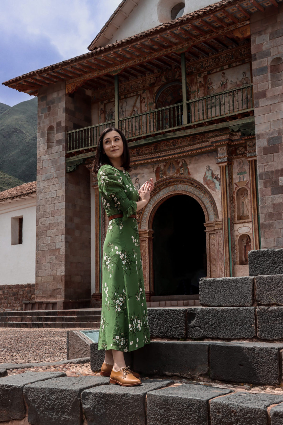 Travel Blogger Jordan Gassner clasping her hands together in front of Andahuaylillas Church near Cusco, Peru