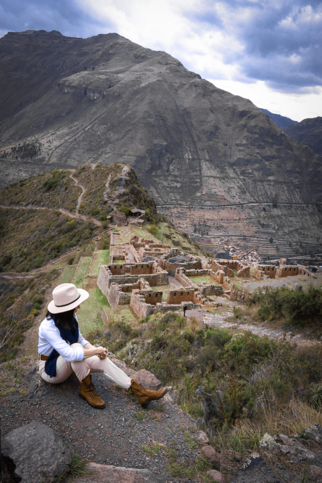 Cusco Travel Guide: Travel Blogger Jordan Gassner sitting from a view point high above some of the ruins in Pisac, Peru