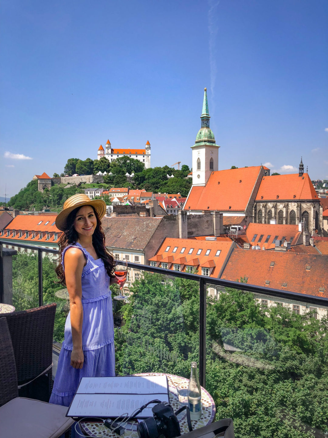 Travel Blogger Jordan Gassner holding a glass of rose on top of the Lemontree & Sky Bar Restaurant balcony in Bratislava, Slovakia