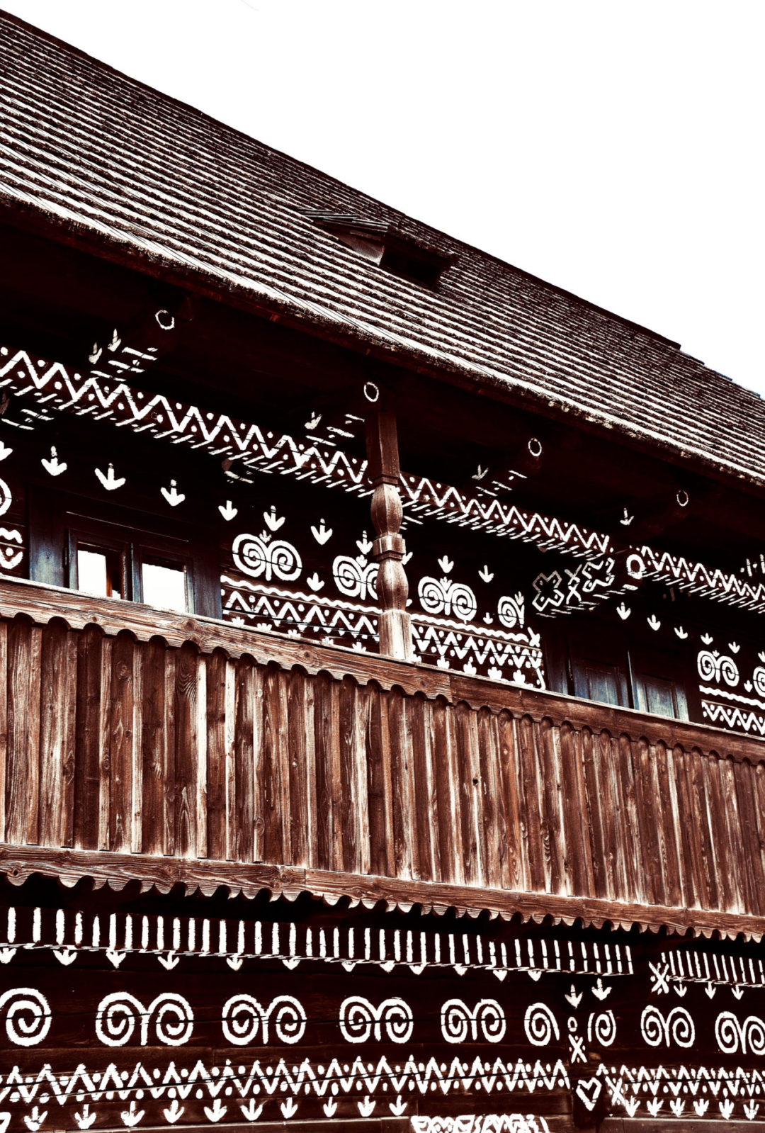 White circular and geometric folk paintings on a traditional wooden building in Čičmany Village, Slovakia
