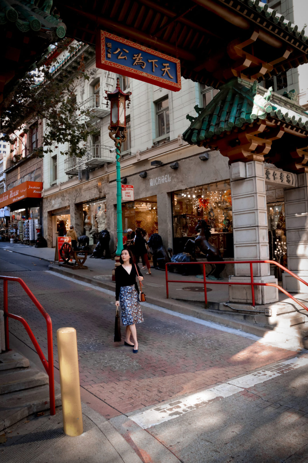 Travel Blogger Jordan Gassner holding a shopping bag while walking through the Dragon's Gat Archway of San Francisco's Chinatown