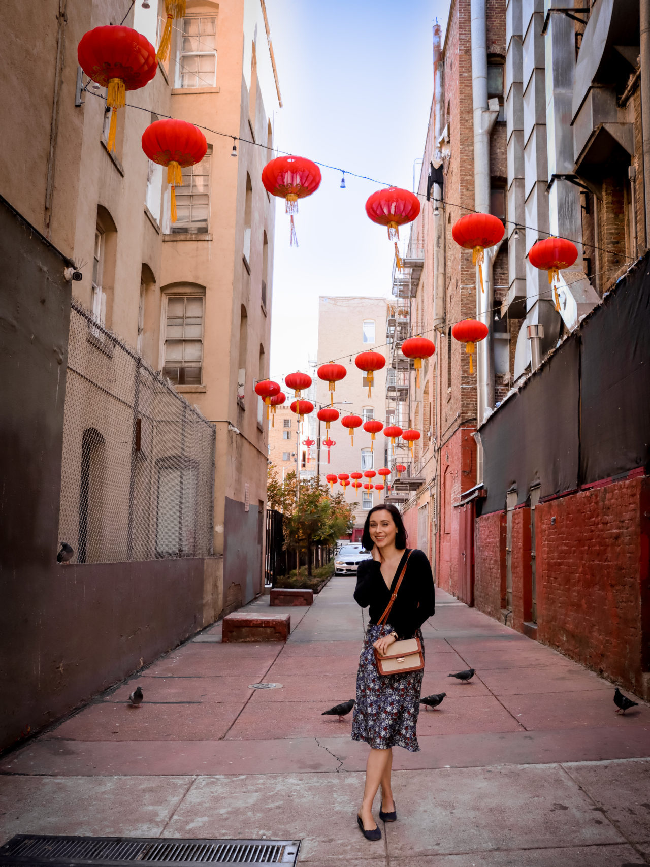 Travel Blogger Jordan Gassner standing and smiling in Chinatown's Hang Ah street, where red lanterns hang overhead