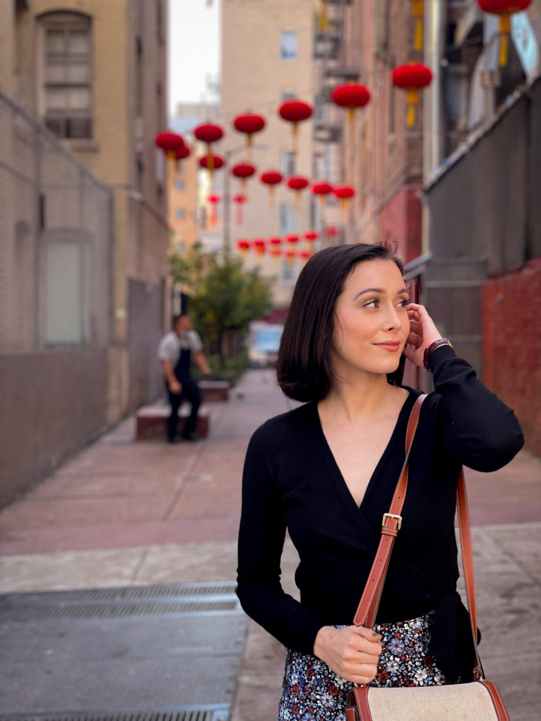 Travel Blogger Jordan Gassner brushing her hair behind her ear in the lantern-strewn Hang Ah Street of San Francisco's Chinatown